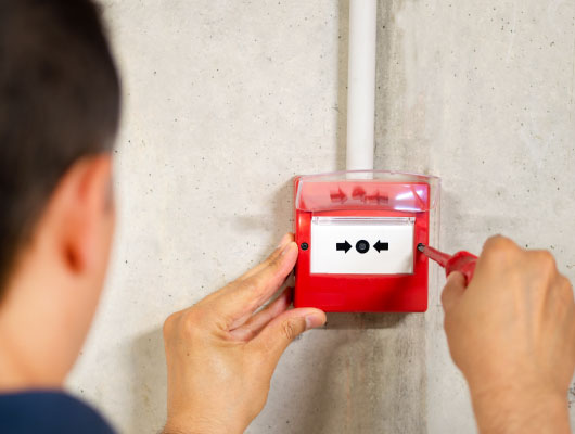 a worker installing fire alarm system