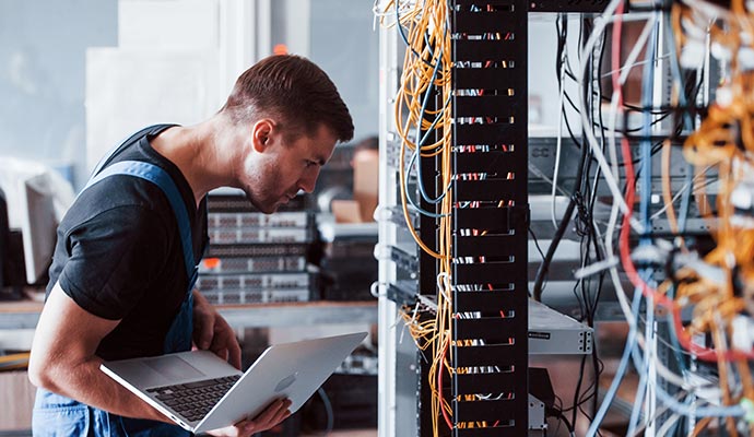 A network engineer working with server racks.